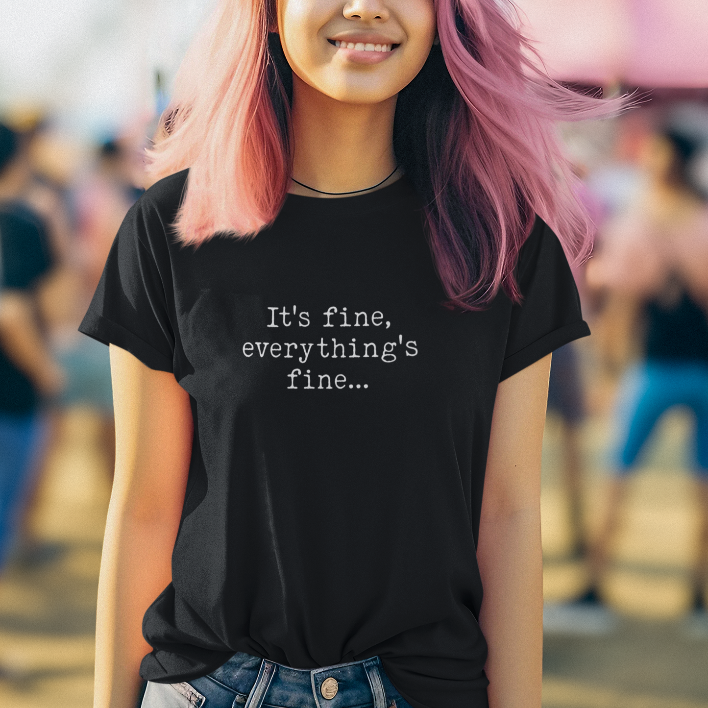 Person wearing a black t-shirt with 'It's fine, everything's fine...' text at an outdoor event.