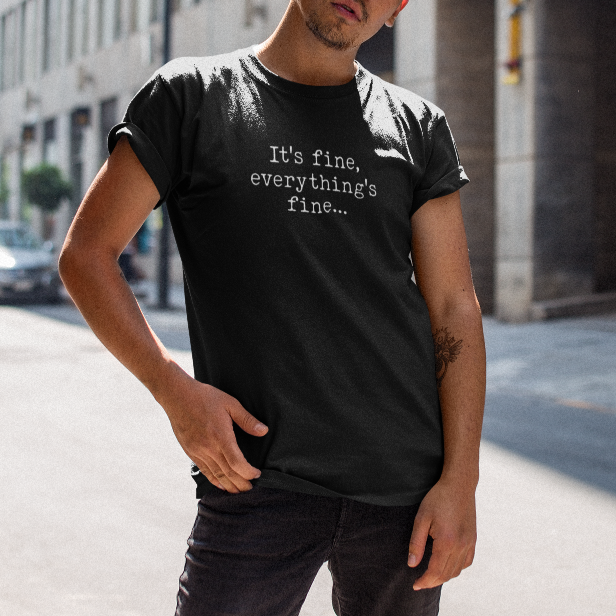 Man wearing a black t-shirt with text on a city street