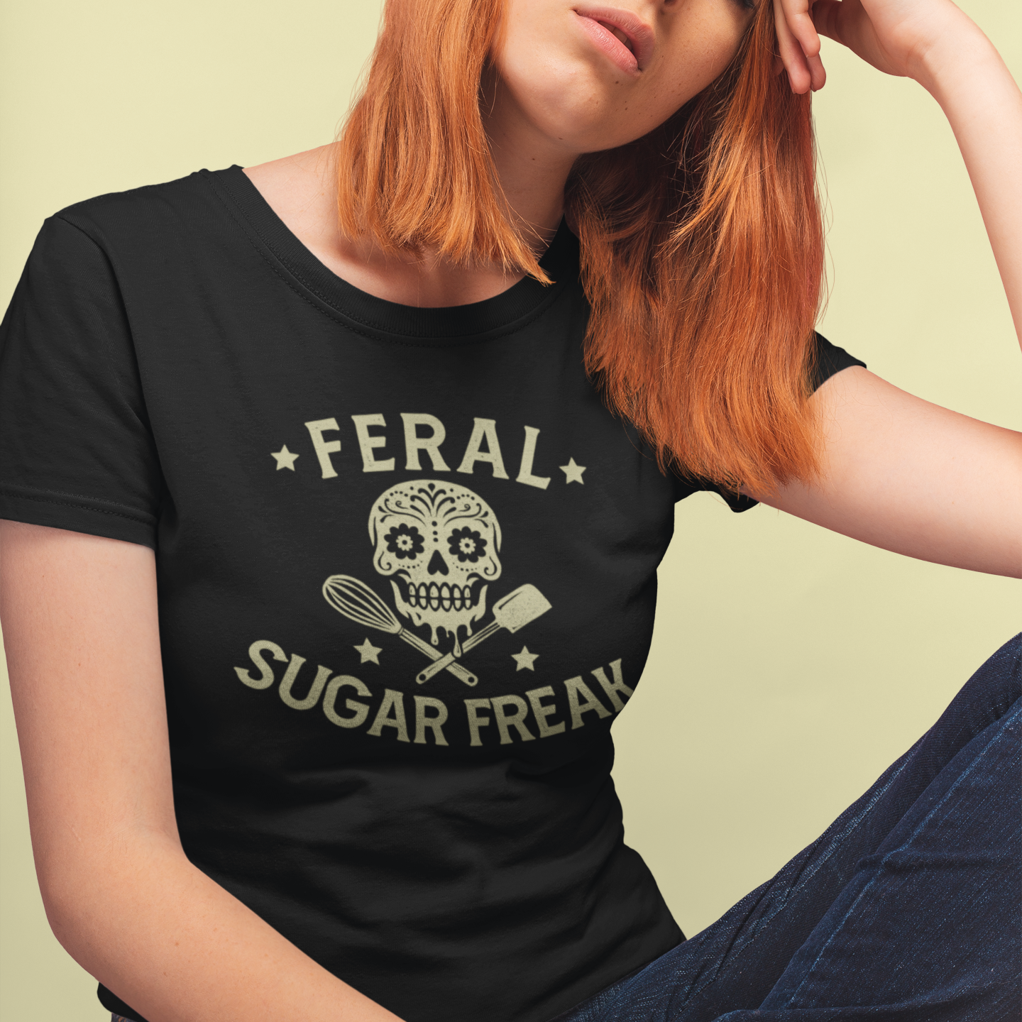 Person wearing a black t-shirt with 'Feral Sugar Freak' design on a light green background