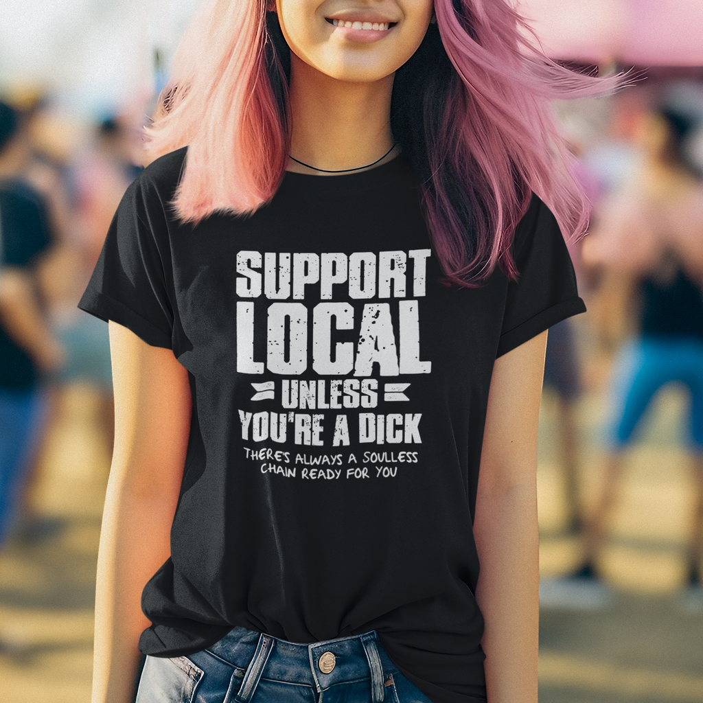 Person wearing a black t-shirt with 'Support Local Unless You're a Dick' text, standing outdoors.