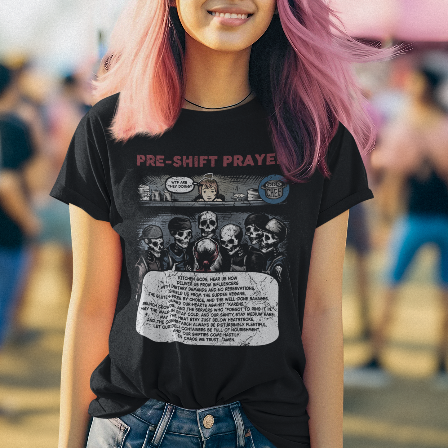 Person with pink hair wearing a black t-shirt with graphic design and text.