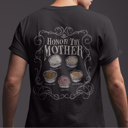 A man shown from the back wearing a black t-shirt with a detailed graphic on the back that reads 'HONOR THY MOTHER' above six circular illustrations, set against a dark gray studio background.