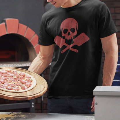 A man in a black graphic t-shirt holding a freshly baked pizza on a wooden board in front of a brick pizza oven.