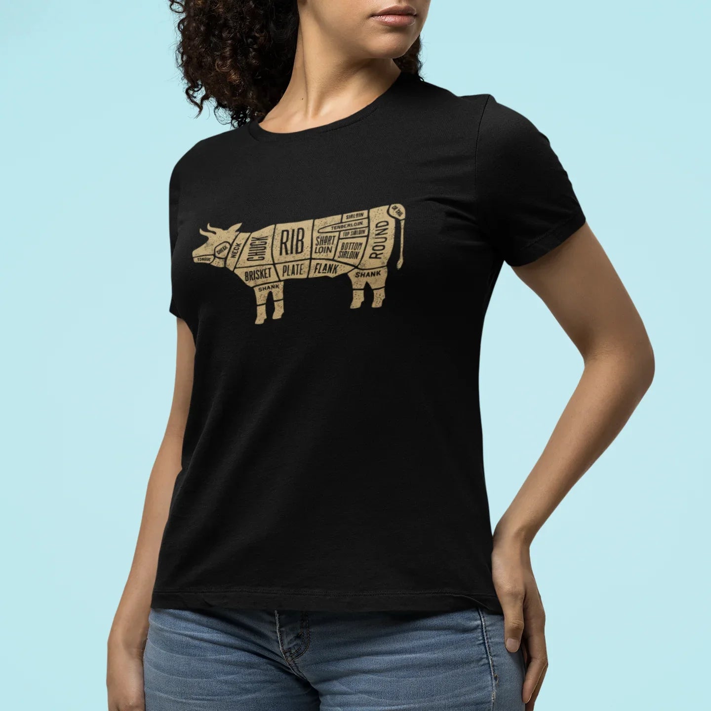 Woman wearing a black t-shirt with a cow diagram graphic on a light blue background