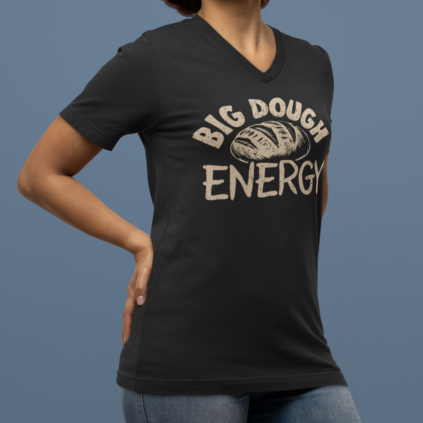 Person wearing a black t-shirt with 'Big Dough Energy' text and bread graphic on a blue background
