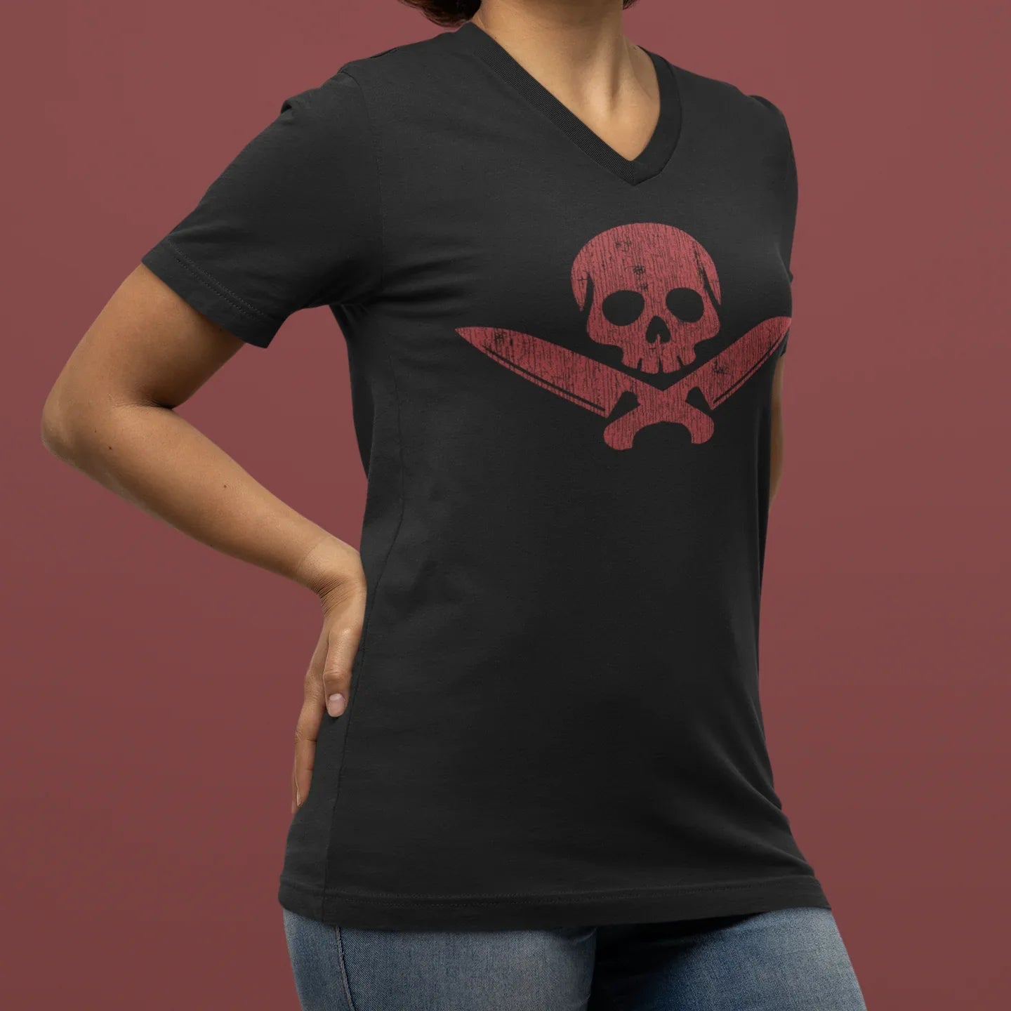 Person wearing a black t-shirt with a red skull design on a brown background