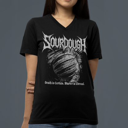 A woman wearing a black V-neck t-shirt with a white 'Sourdough' band graphic on the front, paired with blue jeans, set against a solid dark gray background.