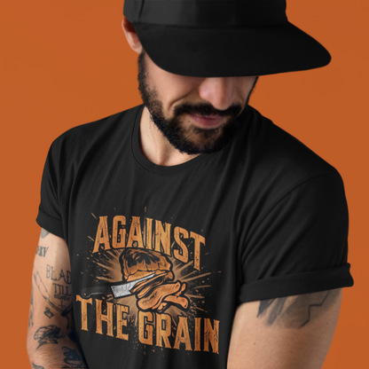 Man wearing a black t-shirt with 'Against The Grain' graphic design on an orange background