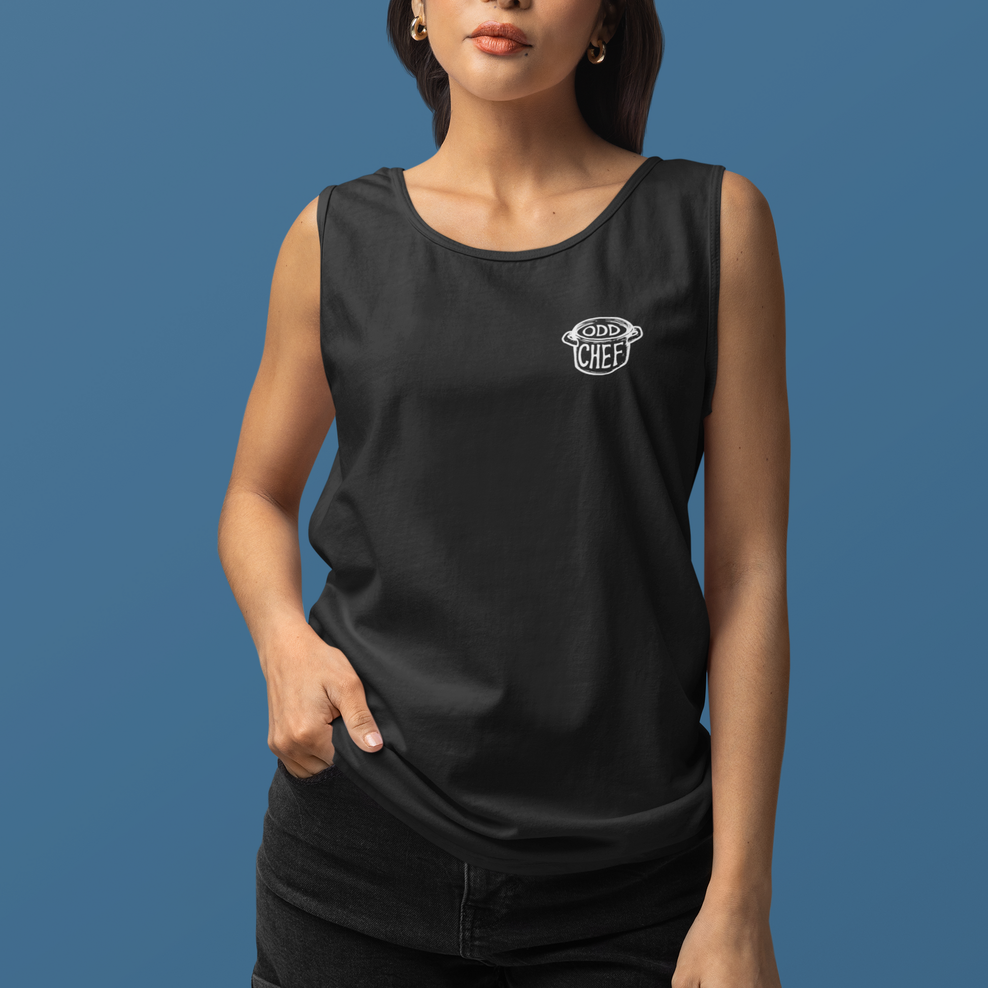 A woman modeling a black sleeveless tank top with a small white circular chest graphic that reads 'GOOD TO LEAF', paired with black shorts, against a solid blue studio background.