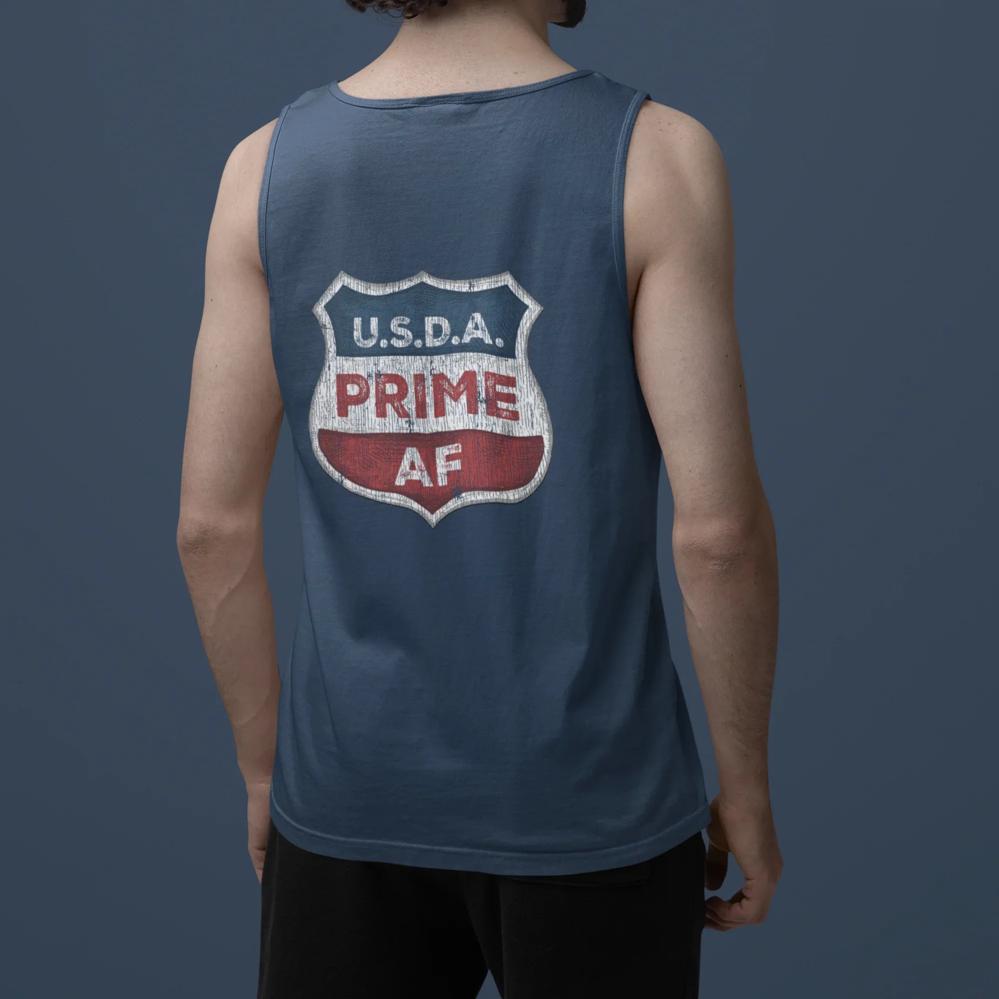 Person wearing a blue tank top with 'U.S.D.A. Prime AF' text on the back against a dark background