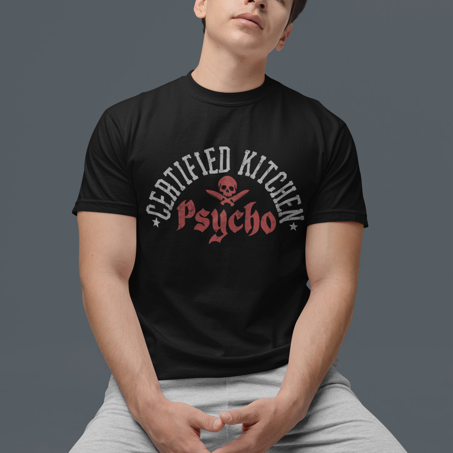 Person wearing a black t-shirt with a graphic design on a gray background