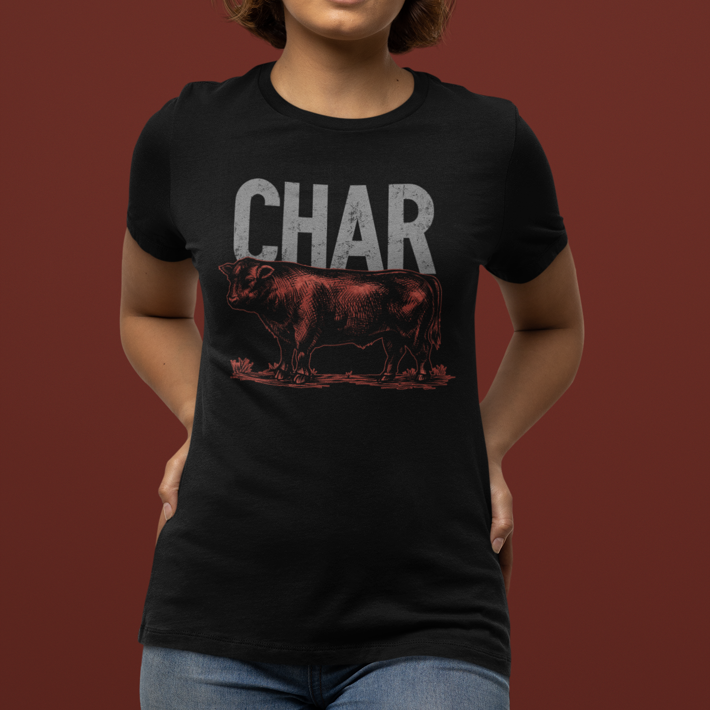 Person wearing a black t-shirt with a graphic design and the word 'CHAR' on a brown background