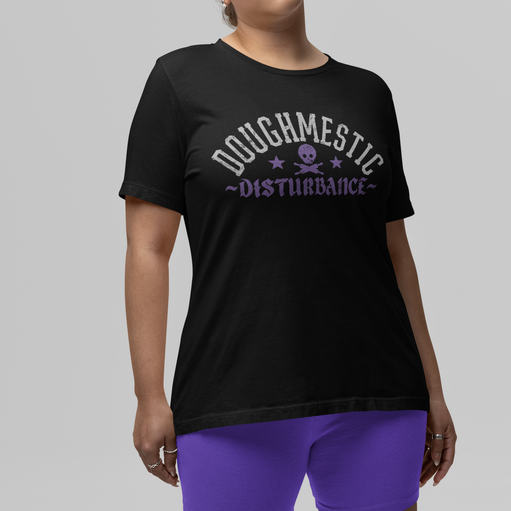 Woman wearing a black t-shirt with text and purple shorts on a gray background