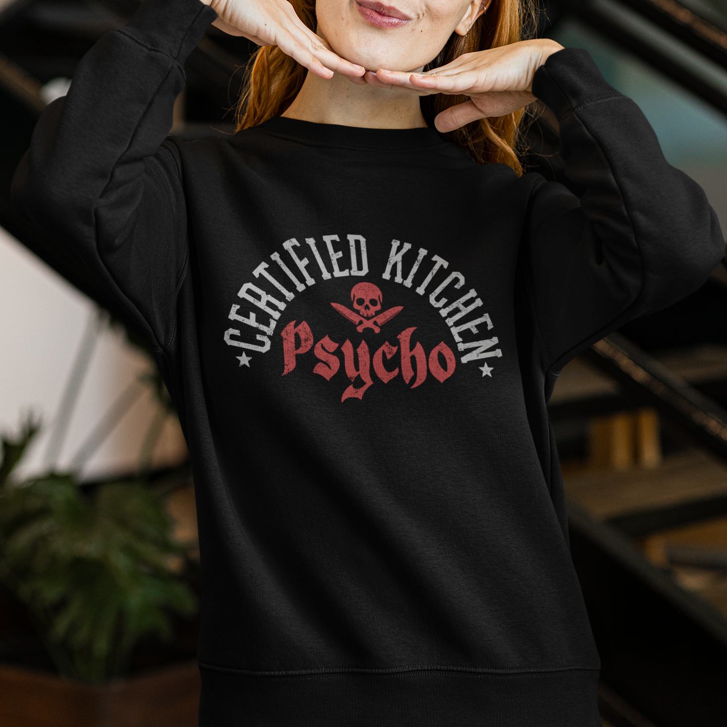 Person wearing a black sweatshirt with 'Certified Kitchen Psycho' text and skull design.