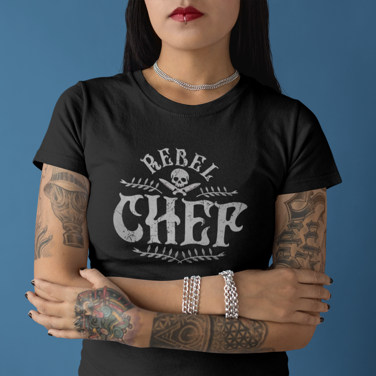 Person wearing a black t-shirt with 'Rebel Chef' design against a blue background