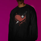 Person wearing a black sweatshirt with a graphic design on a pink background