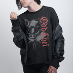 Person wearing a black sweatshirt with graphic design and text on a plain background