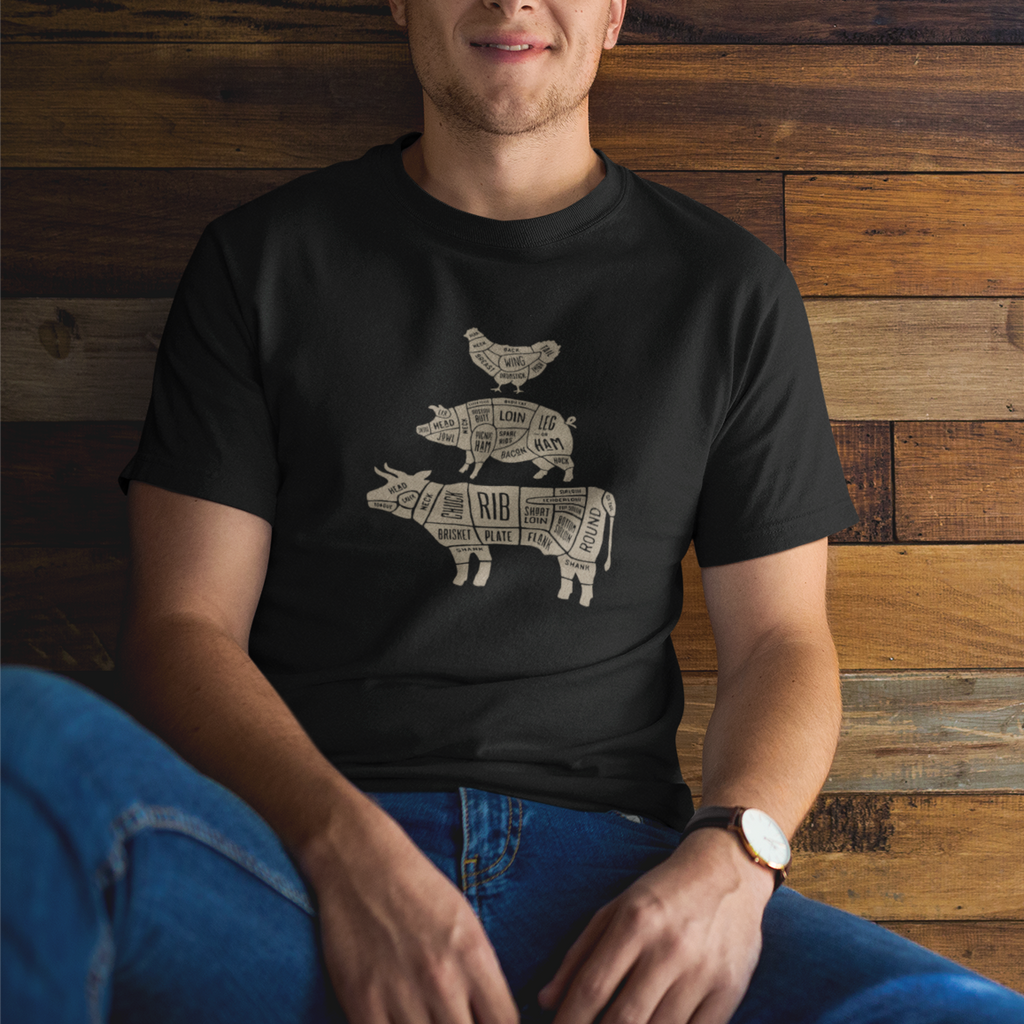 Man wearing a black t-shirt with a graphic design sitting against a wooden wall.