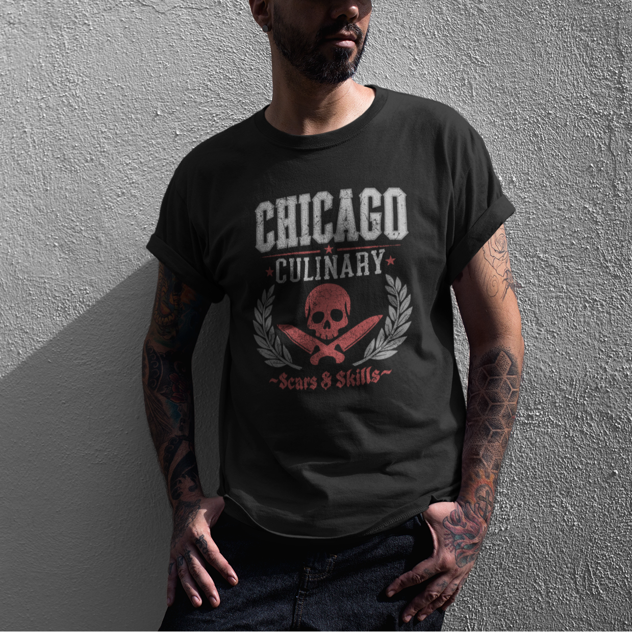 Man wearing a black t-shirt with 'Chicago Culinary' design against a gray wall