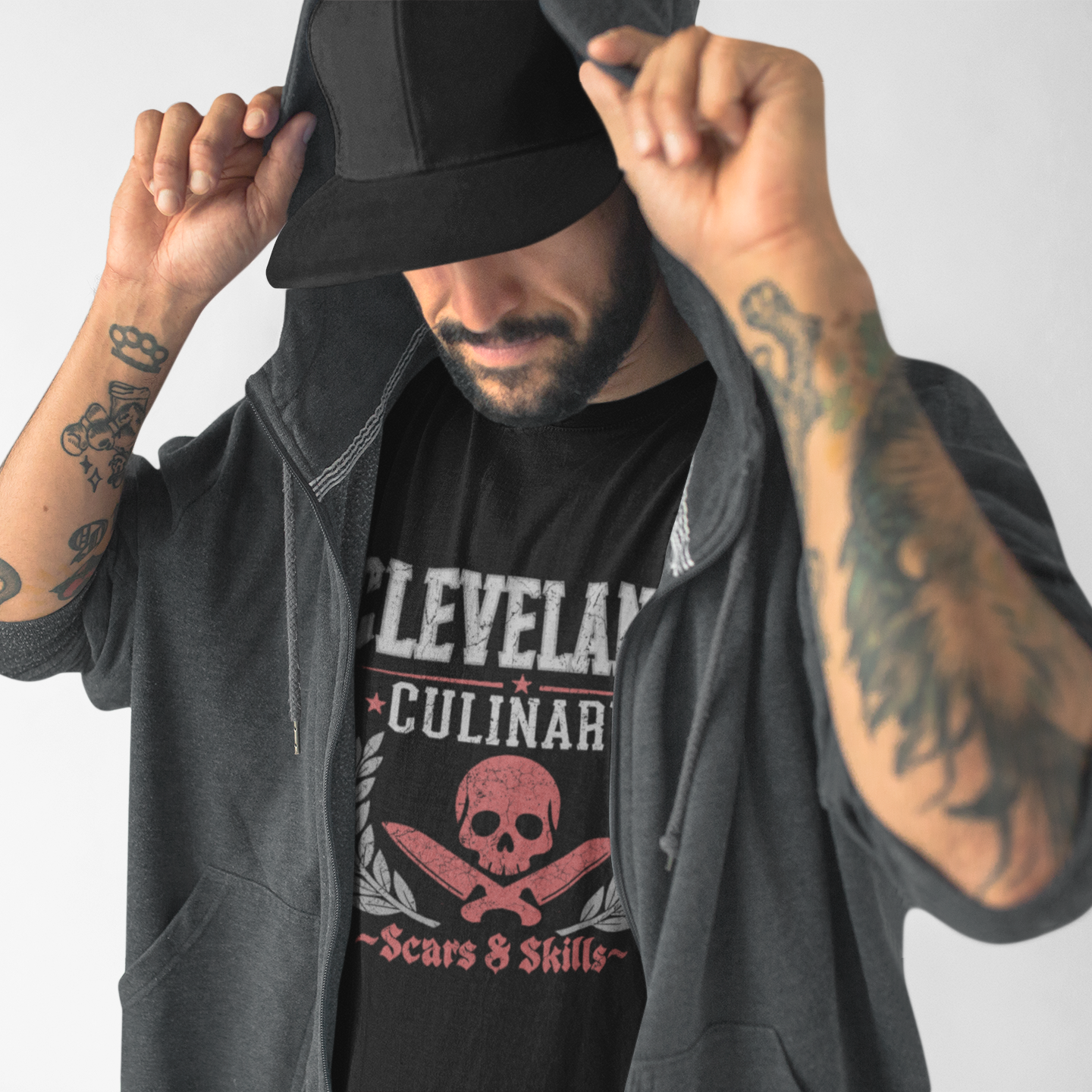 Man wearing a black hoodie and a black t-shirt with 'Cleveland Culinary' design on a light gray background
