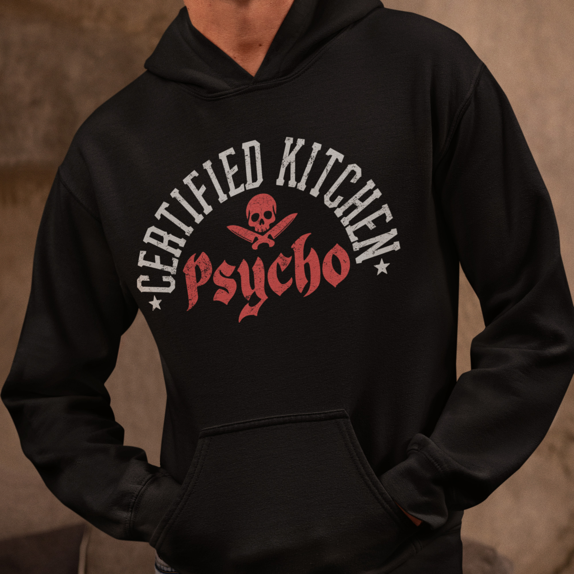 Person wearing a black hoodie with 'Certified Kitchen Psycho' text and skull design.