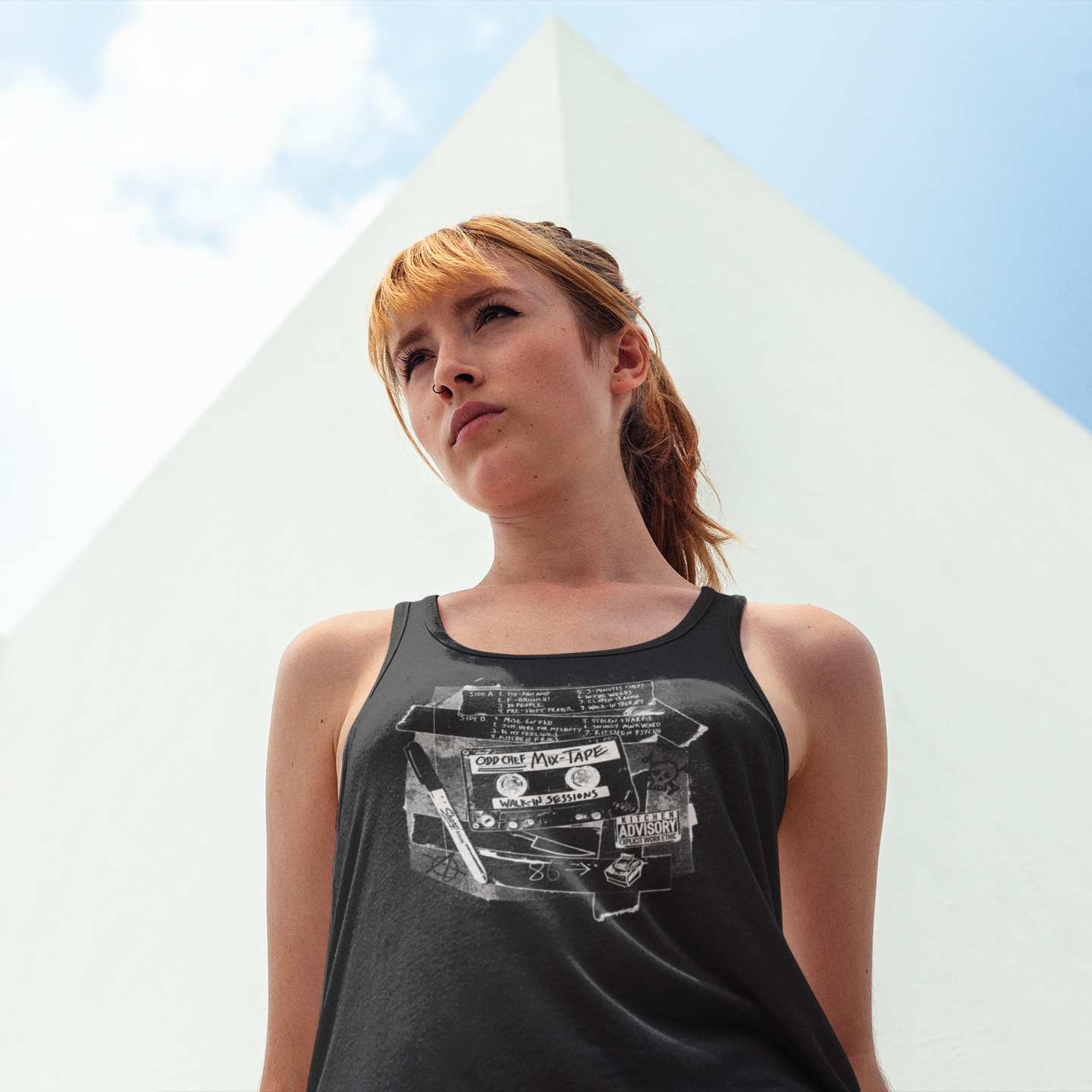 Woman wearing a black tank top with graphic design outdoors
