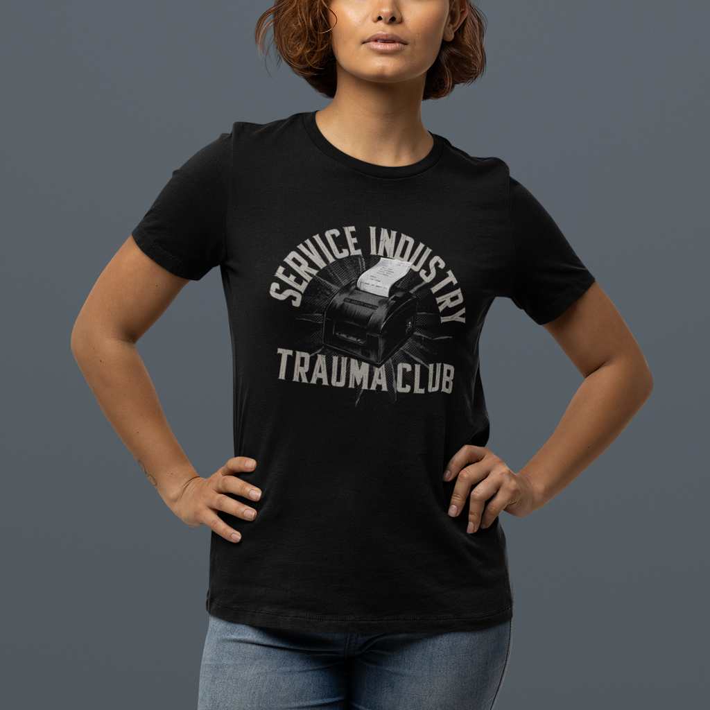 Person wearing a black t-shirt with 'Service Industry Trauma Club' text and graphic on a gray background