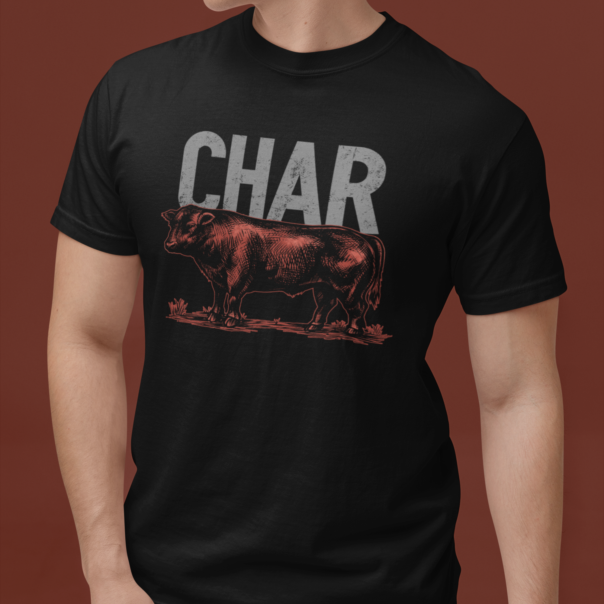 Person wearing a black t-shirt with a graphic of a cow and the word 'CHAR' on a brown background