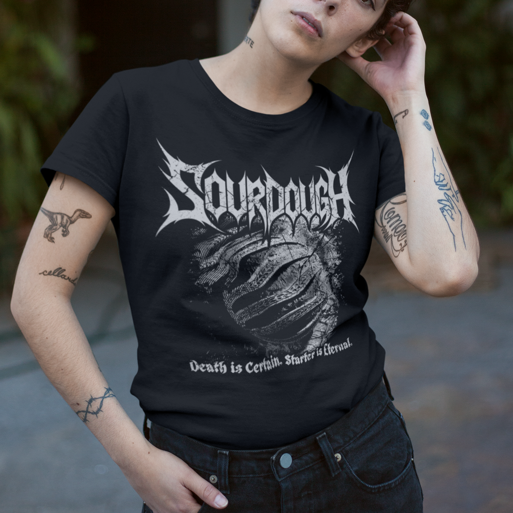 Person wearing a black t-shirt with 'Sourdough' design, standing outdoors.