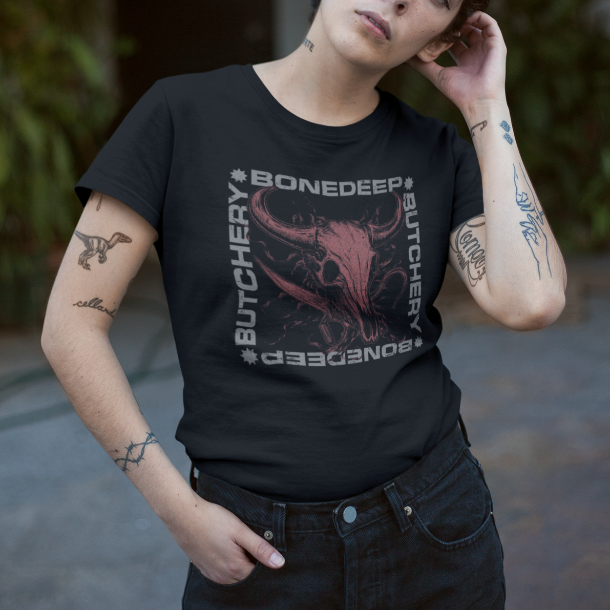 Person wearing a black t-shirt with graphic design and text, standing outdoors.