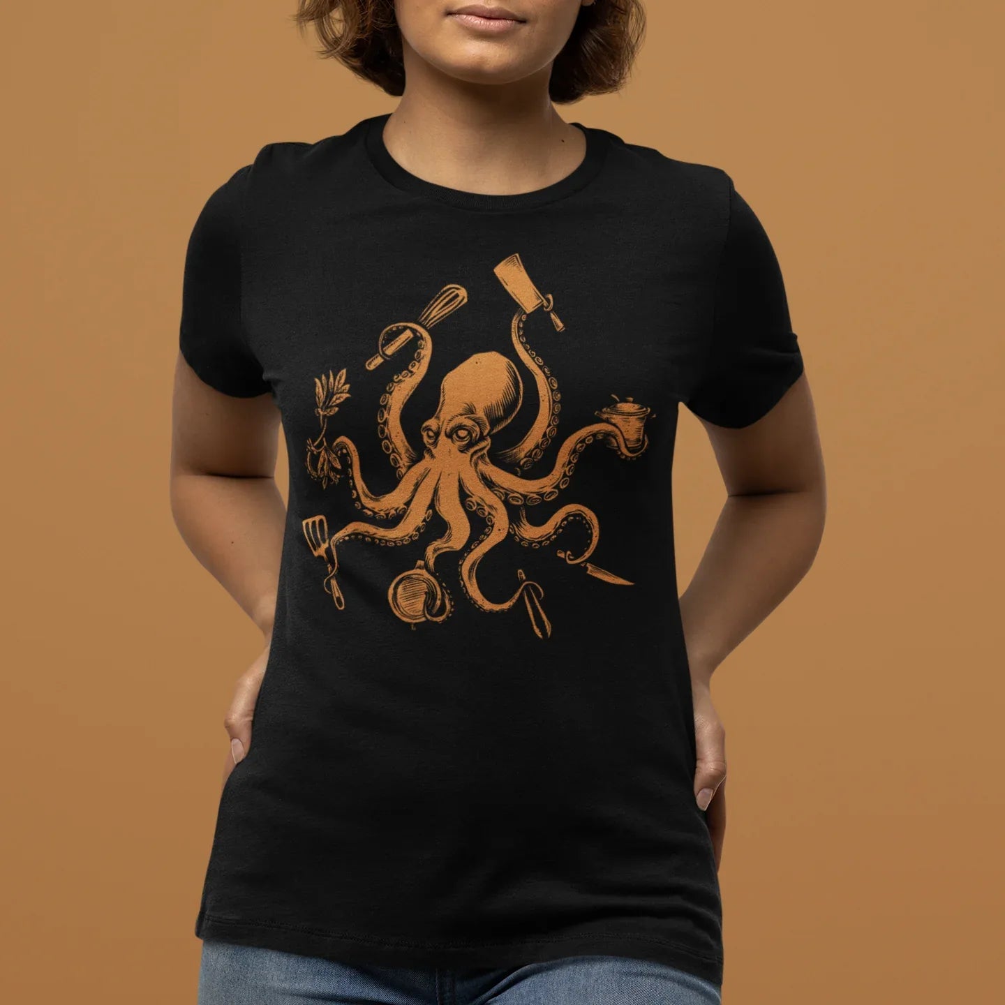 Person wearing a black t-shirt with an octopus design on a brown background