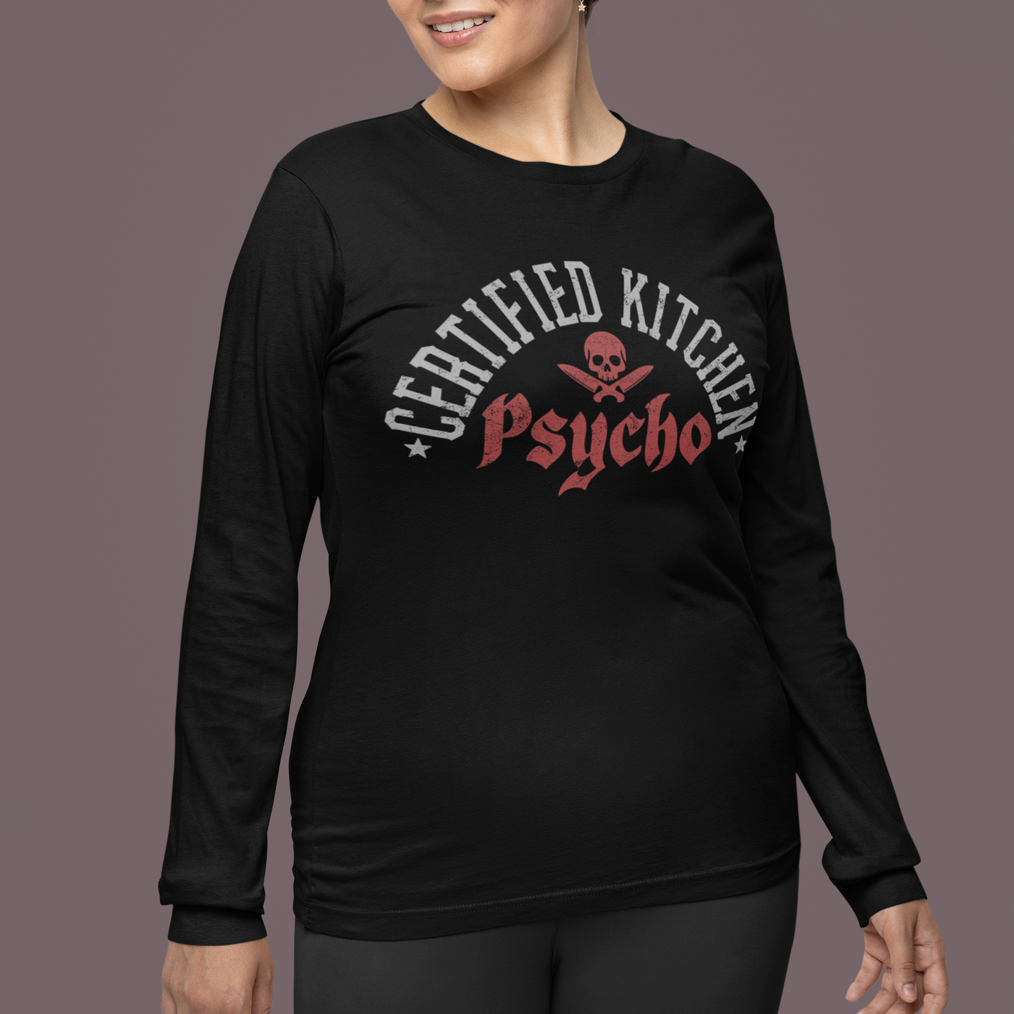 Woman wearing a black long-sleeve shirt with 'Certified Kitchen Psycho' text on a dark background