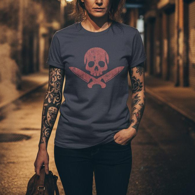 Woman wearing a t-shirt with a skull design on a dark alleyway.