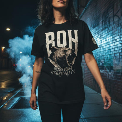 Person wearing a black t-shirt with a bear graphic and text in an urban setting at night.