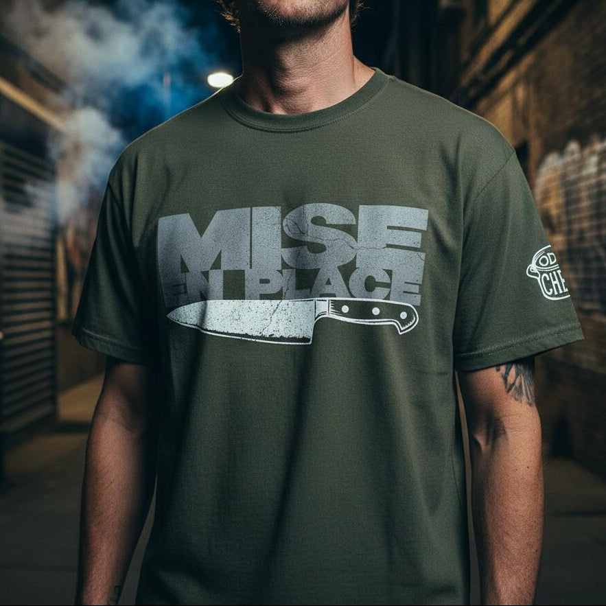 Man wearing a green t-shirt with a logo and text, standing in an urban setting.