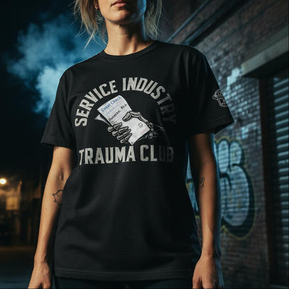 Person wearing a black t-shirt with graphic design and text in an urban setting at night.