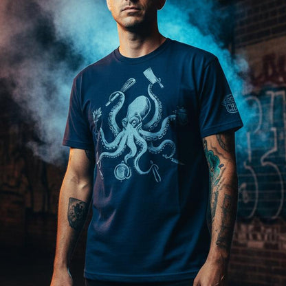 Man wearing a blue t-shirt with an octopus design in front of a graffiti-covered wall.