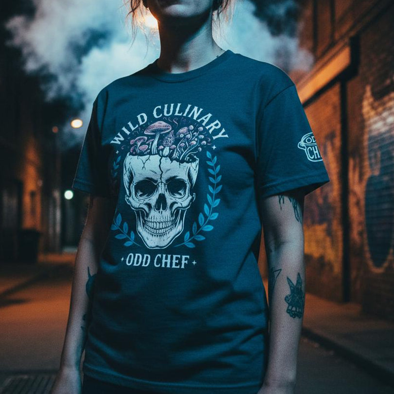 Person wearing a blue t-shirt with a skull design and text on a dark street.