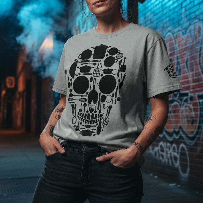 Person wearing a gray t-shirt with a skull design in an urban setting at night.