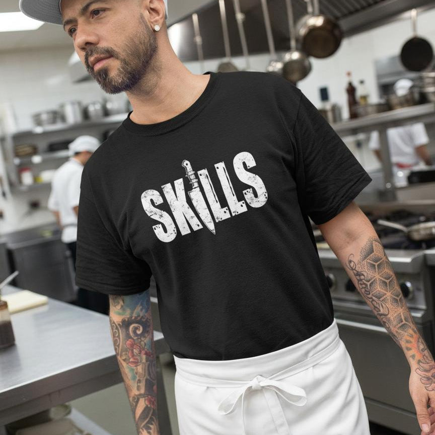 Man wearing a black 'SKILLS' t-shirt in a kitchen setting
