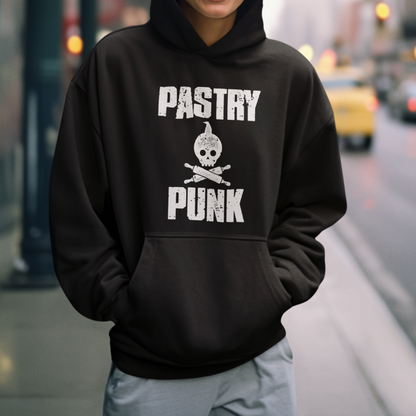 A woman smiling on a city street wearing a black pullover hoodie with 'PASTRY PUNK' and a skull graphic printed in white on the front.