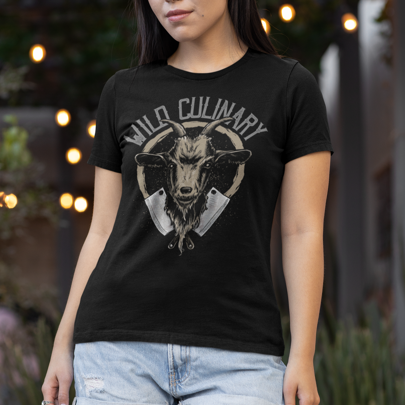 Woman wearing a black t-shirt with a graphic design outdoors.