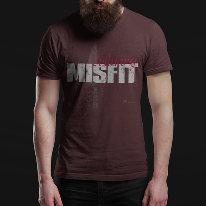 A man with a full beard and sunglasses wearing a dark brown t-shirt with a distressed graphic that reads 'Ordinary Misfit' in gray and red, set against a solid black background.