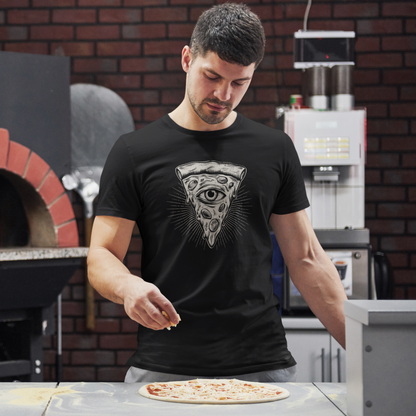 A man wearing a black t-shirt with a detailed grayscale pizza slice graphic featuring an all-seeing eye, standing in a kitchen and sprinkling cheese onto a pizza on a counter.