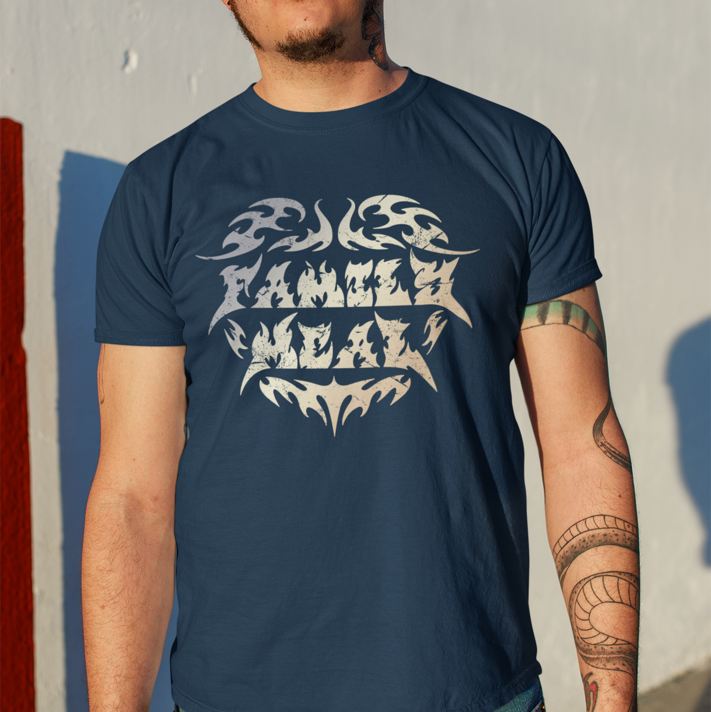 Man wearing a navy blue t-shirt with white graphic design against a gray wall.