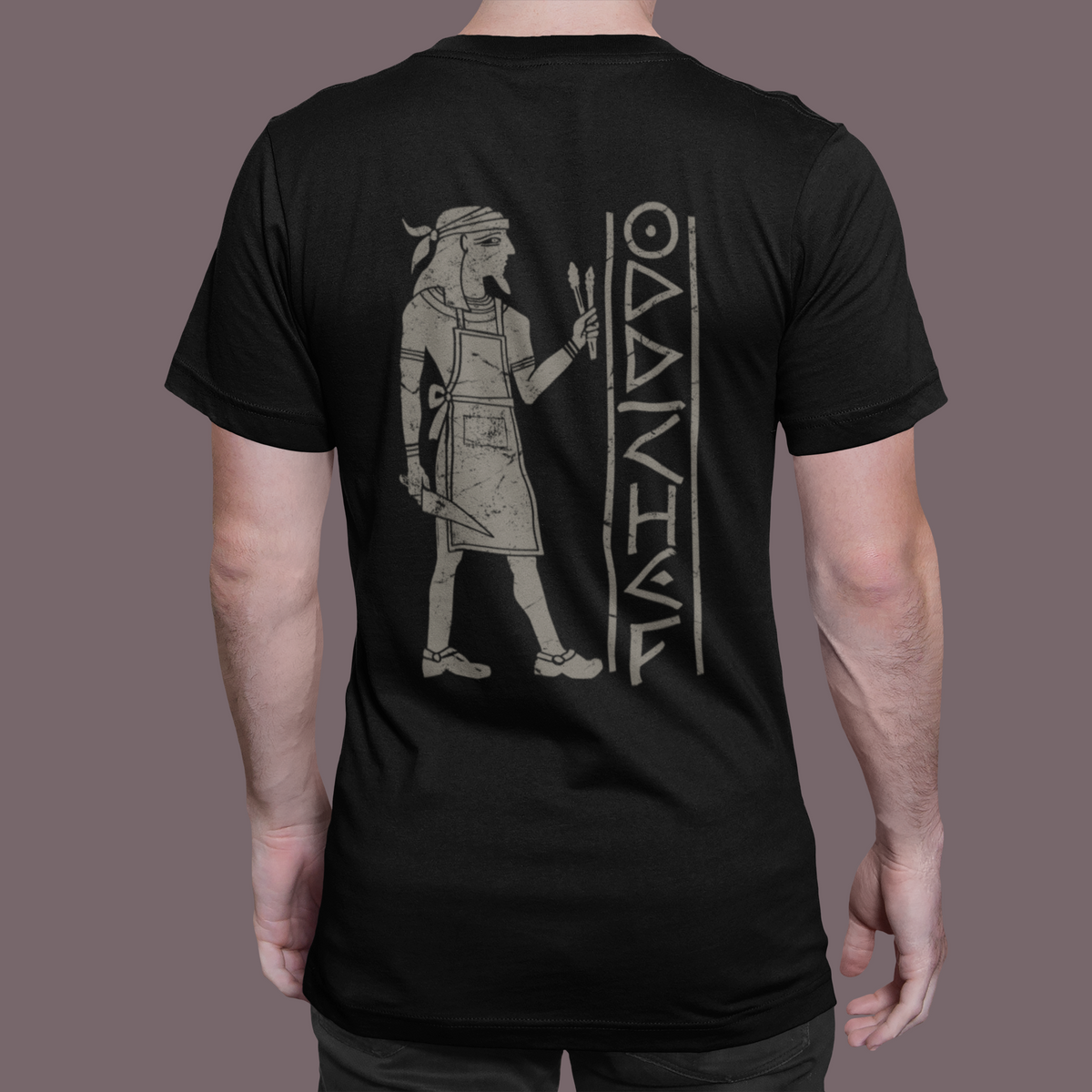 A man viewed from the back wearing a black t-shirt with a large light gray graphic of a Viking warrior and the word 'VANGUARD' printed on the back, set against a solid dark gray background.