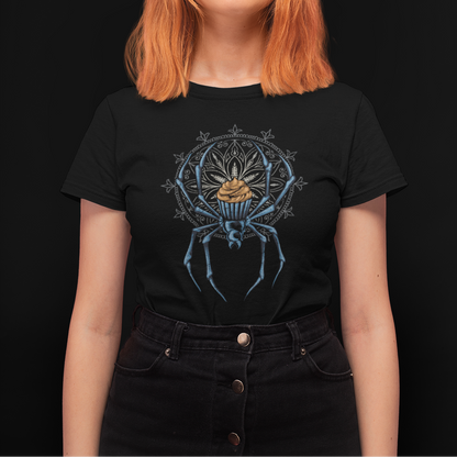 A woman with bright orange hair wearing a black graphic t-shirt featuring a blue spider design with a gold crown, set against a solid black background.