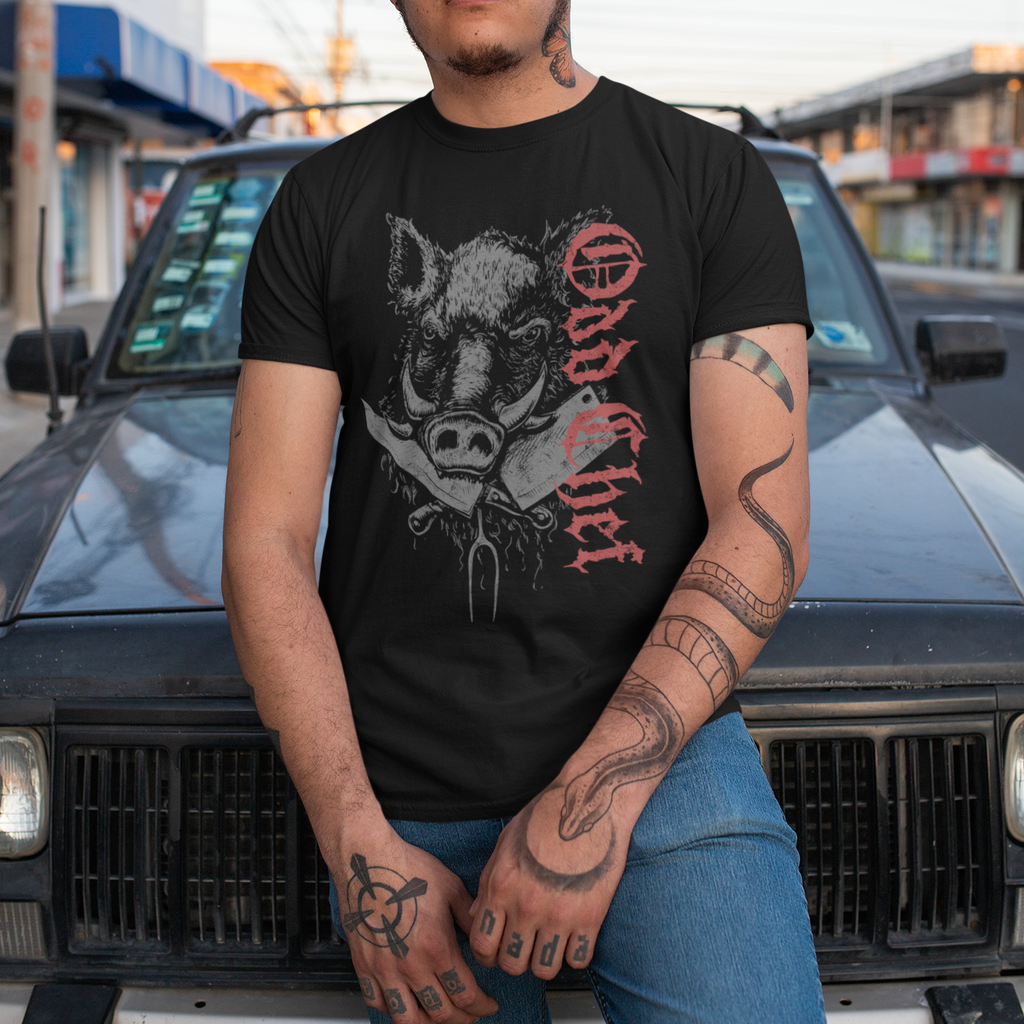 Person wearing a black t-shirt with graphic design and text, standing in front of a vehicle.