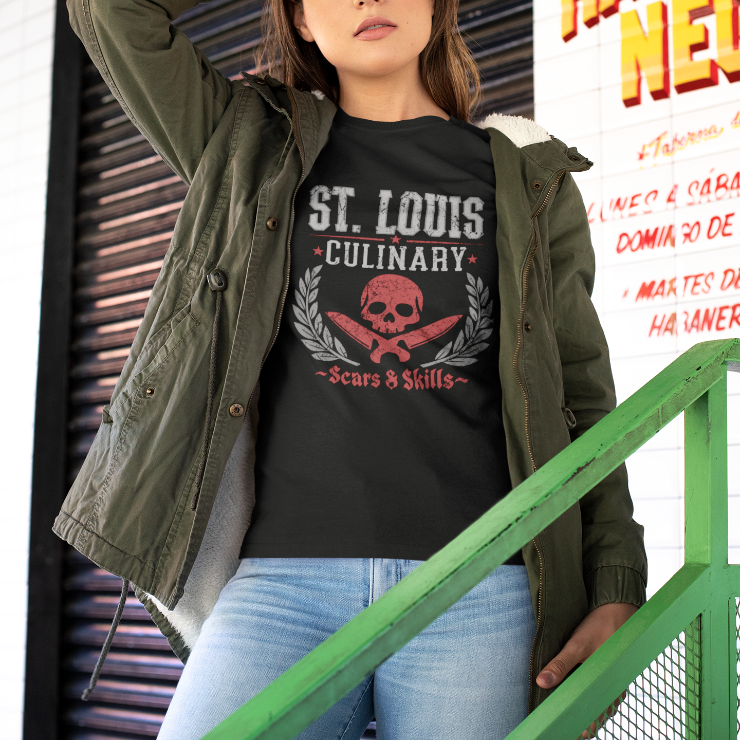 Woman wearing a black t-shirt with 'St. Louis Culinary' design, standing outdoors.