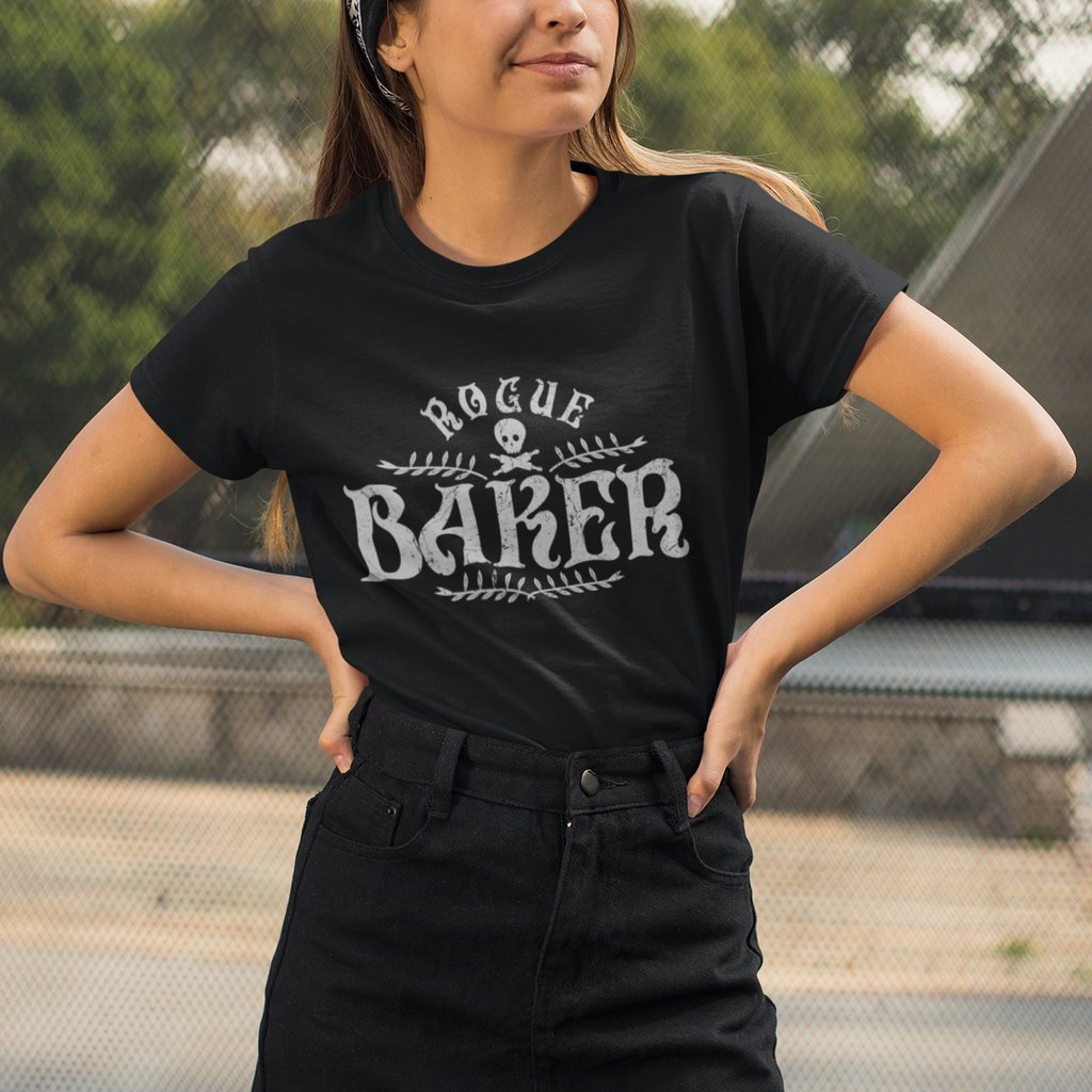 Woman wearing a black t-shirt with 'Rogue Baker' text and graphics outdoors.